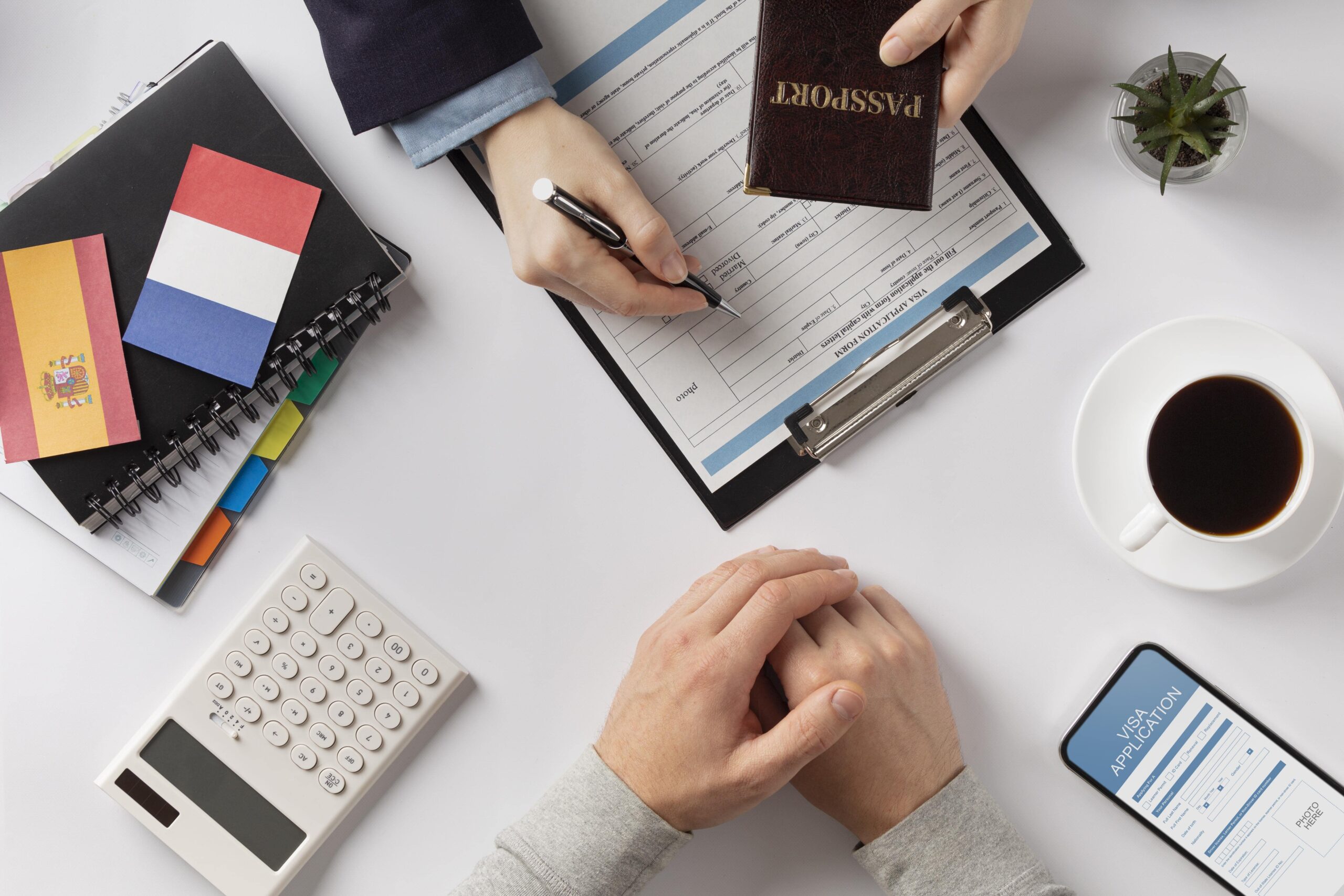 a person filling a document with a pen and a passport