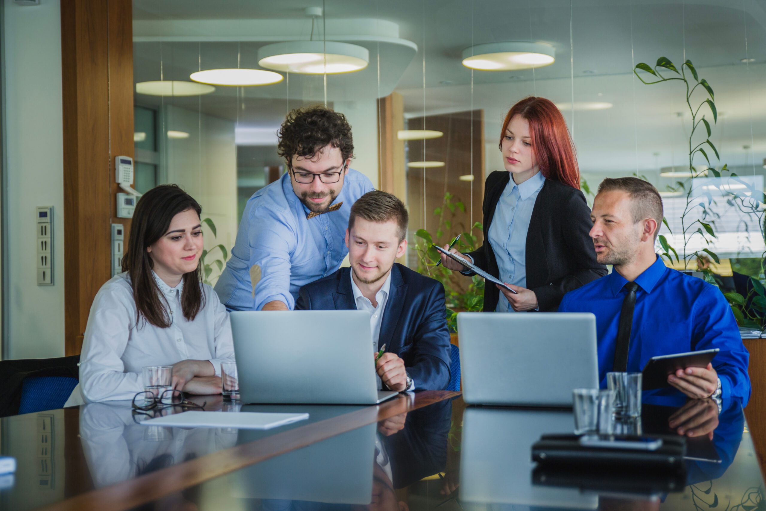 a group of people around a table looking at a laptop