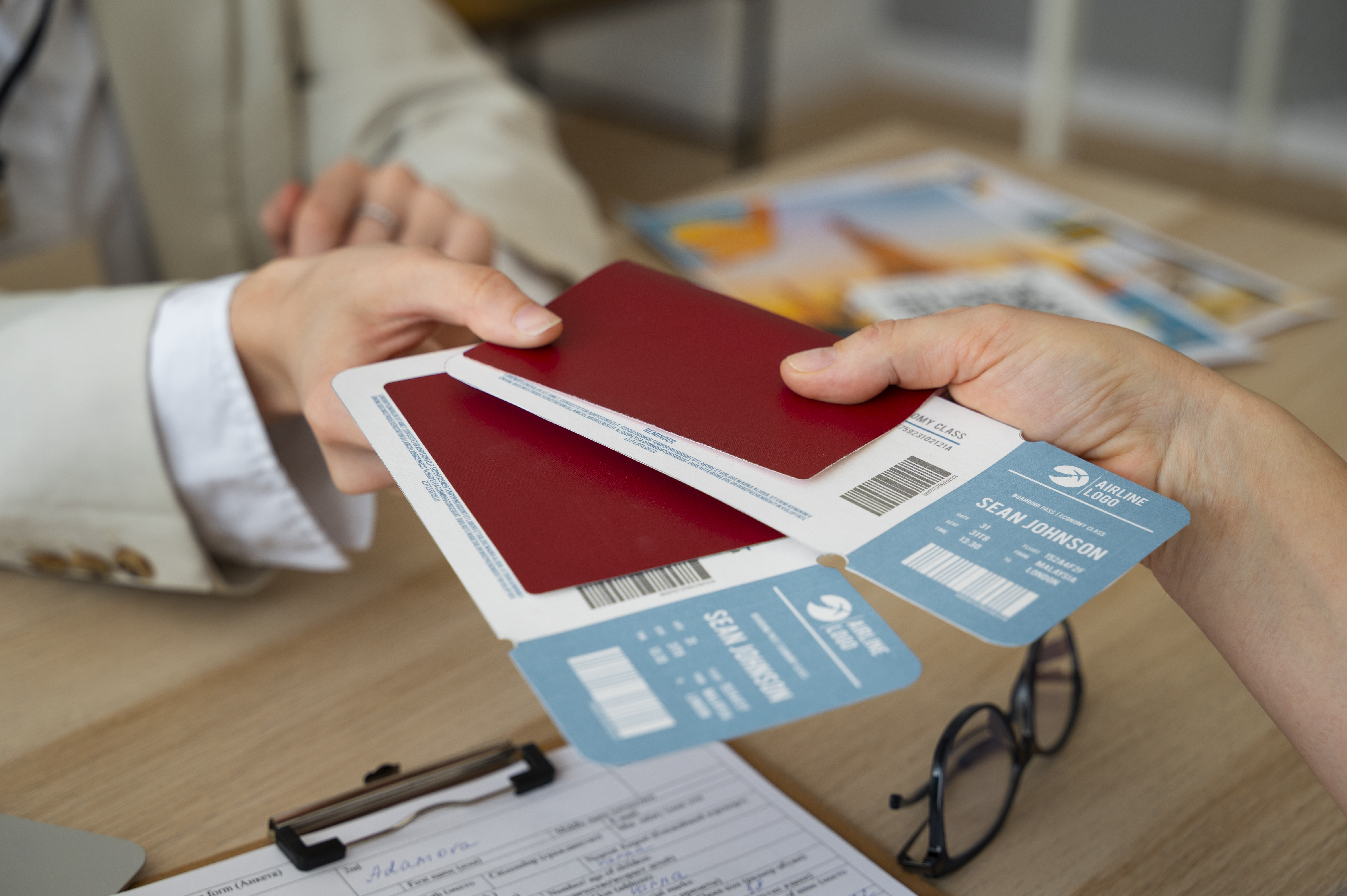 Hands exchanging passports with attached boarding passes.